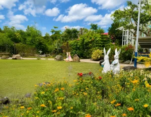 Beautiful garden with colorful flowers, decorative rabbit sculptures, and a spacious green lawn at Wondellea Cafe & Resort, Silang Cavite.