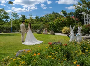 A bride and groom holding hands on a lush green lawn, highlighting the scenic garden wedding venue at Wondellea