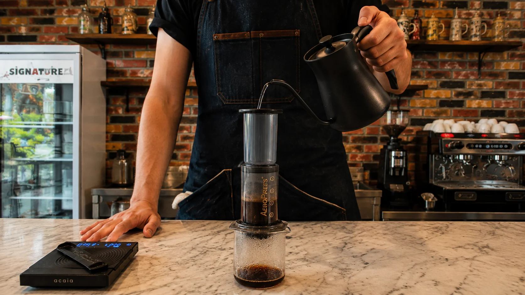 AeroPress brewing method - wondellea cafe Barista pouring hot water into AeroPress at the best coffee shop in Cavite