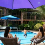 Families relaxing by pool at an event place in Cavite with pool and tropical garden.
