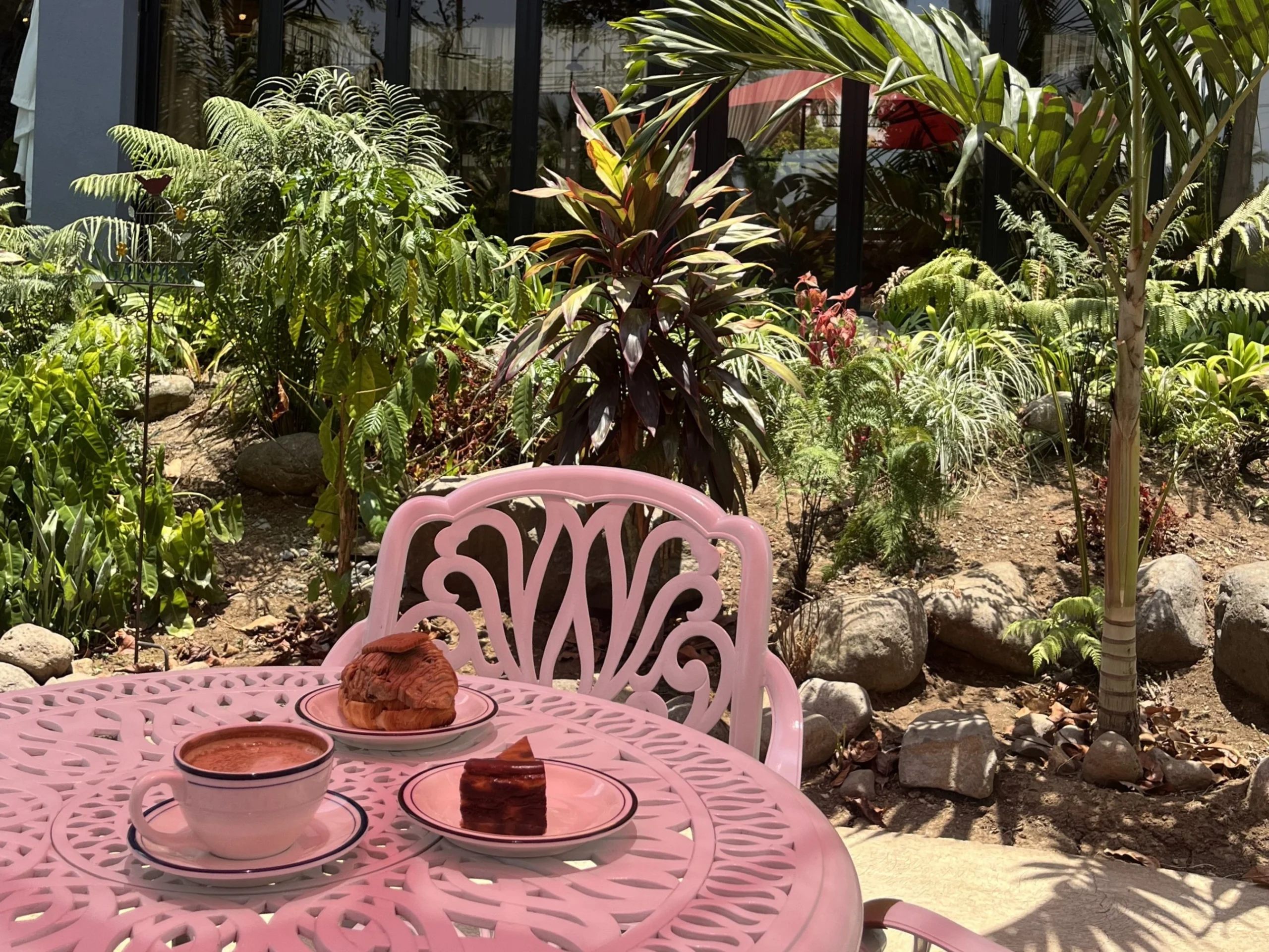 Coffee and pastries on a garden table at an outdoor cafe in Cavite