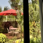 Shaded garden seating at an outdoor cafe in Cavite with a red umbrella
